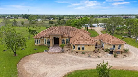 an aerial view of a house with a garden and lake view