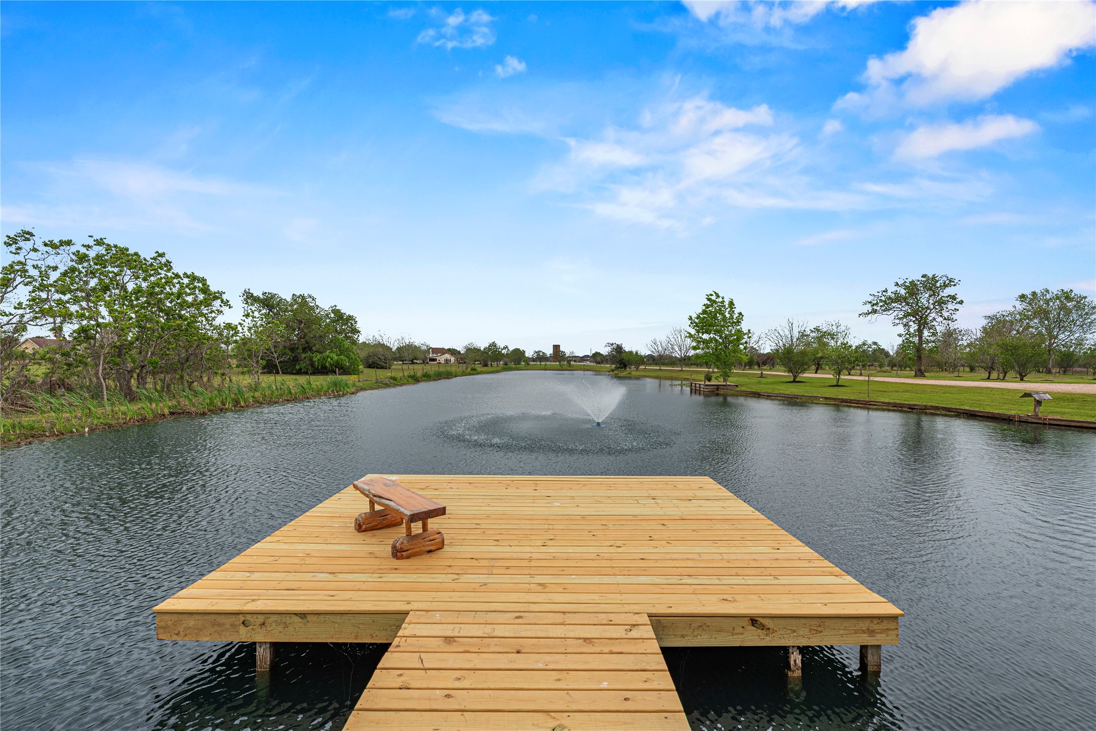 6306 Farm To Market 359 Fulshear, TX 77441 - Photo 6 of 44 This 1-acre stocked lake anchors the estate's grounds, featuring a tranquil fountain and a dedicated fishing pier; the extensive system includes a full gutter system piped directly to the pond for efficient water management.