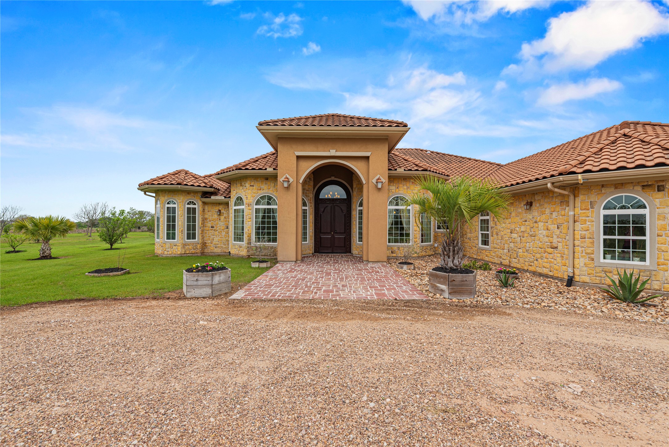 6306 Farm To Market 359 Fulshear, TX 77441 - Photo 7 of 44 The stately stone facade and arched entry sequence feature custom double doors, leading to a sprawling layout that includes an oversized four-car garage for the discerning collector.
