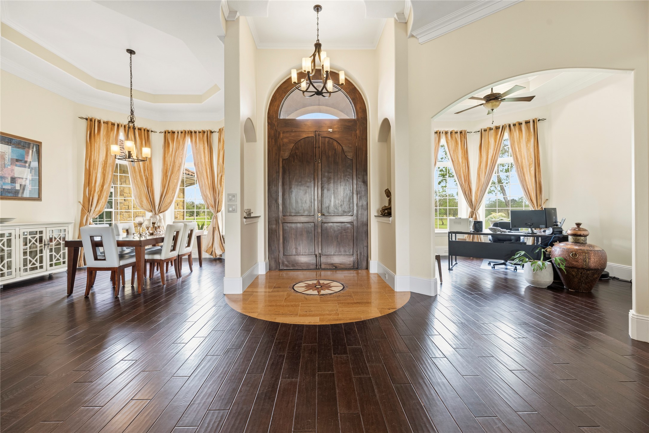 6306 Farm To Market 359 Fulshear, TX 77441 - Photo 8 of 44 Step through the artisan double doors into a magnificent foyer featuring rich engineered wood flooring and high ceilings. The grand open-concept layout creates an inviting and welcoming atmosphere that defines the estate's luxurious interior.