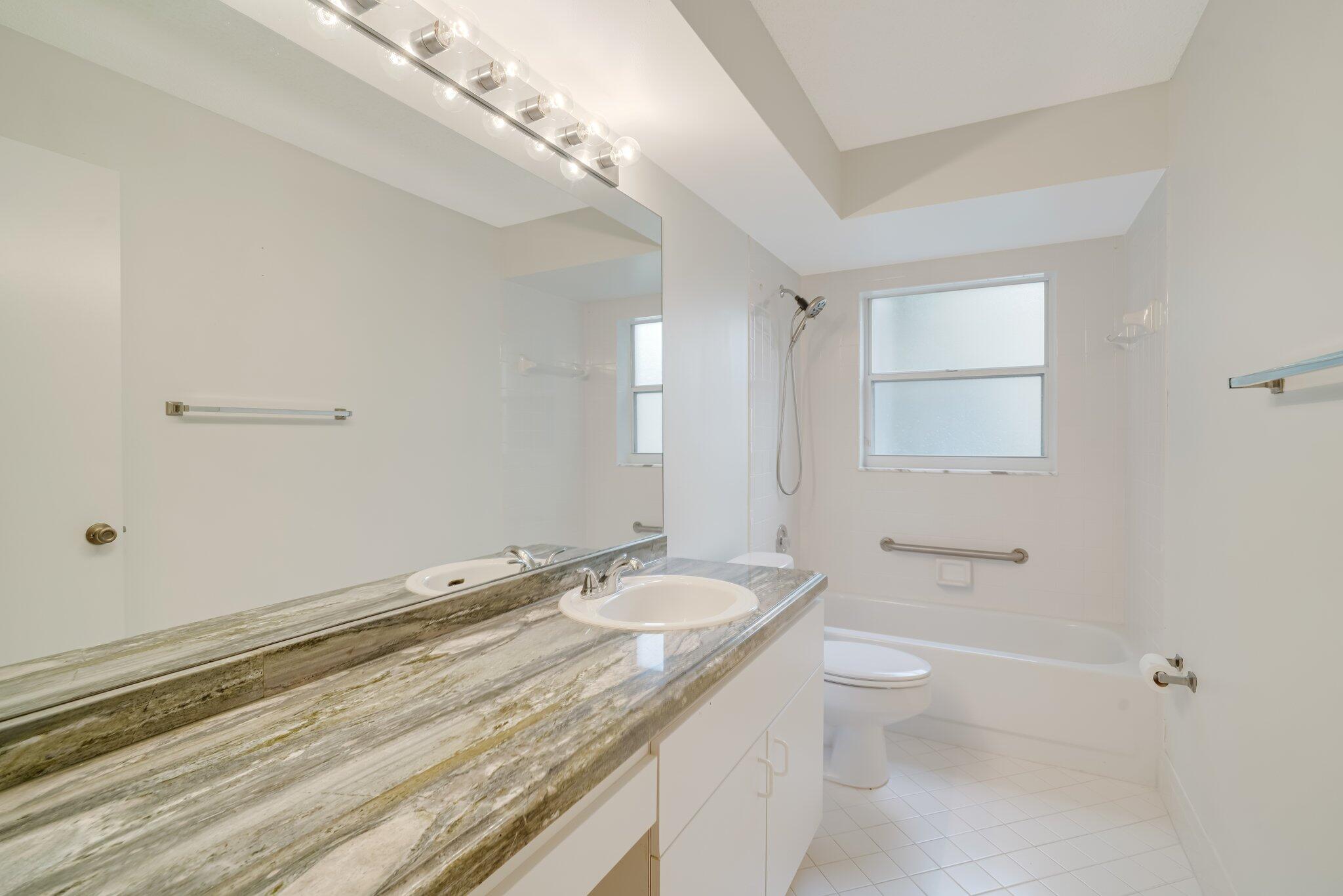 6209 Pond Tree Court Greenacres, FL 33463 - Photo 16 of 38 a bathroom with a granite countertop sink a toilet and shower