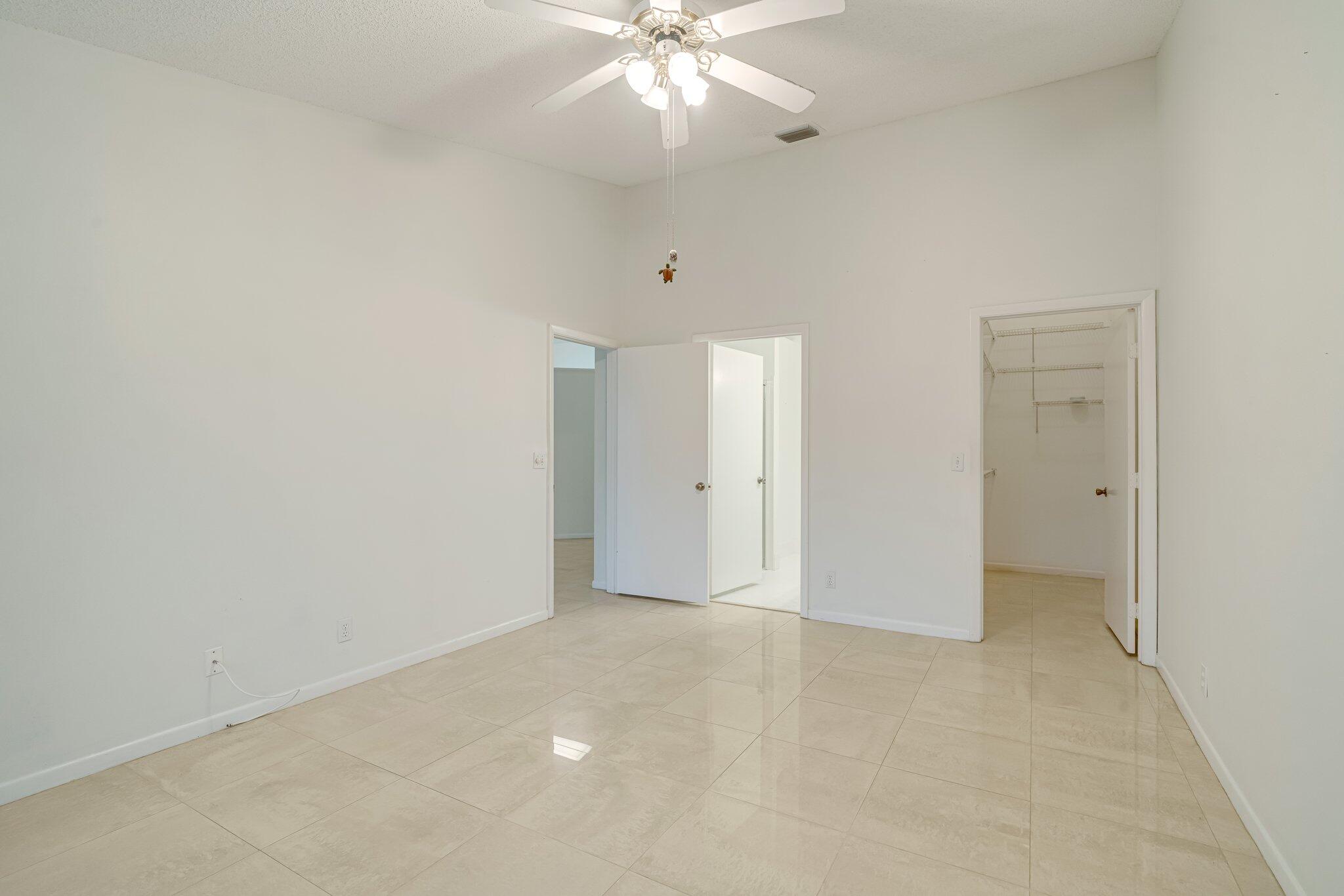 6209 Pond Tree Court Greenacres, FL 33463 - Photo 20 of 38 a view of an empty room with a ceiling fan