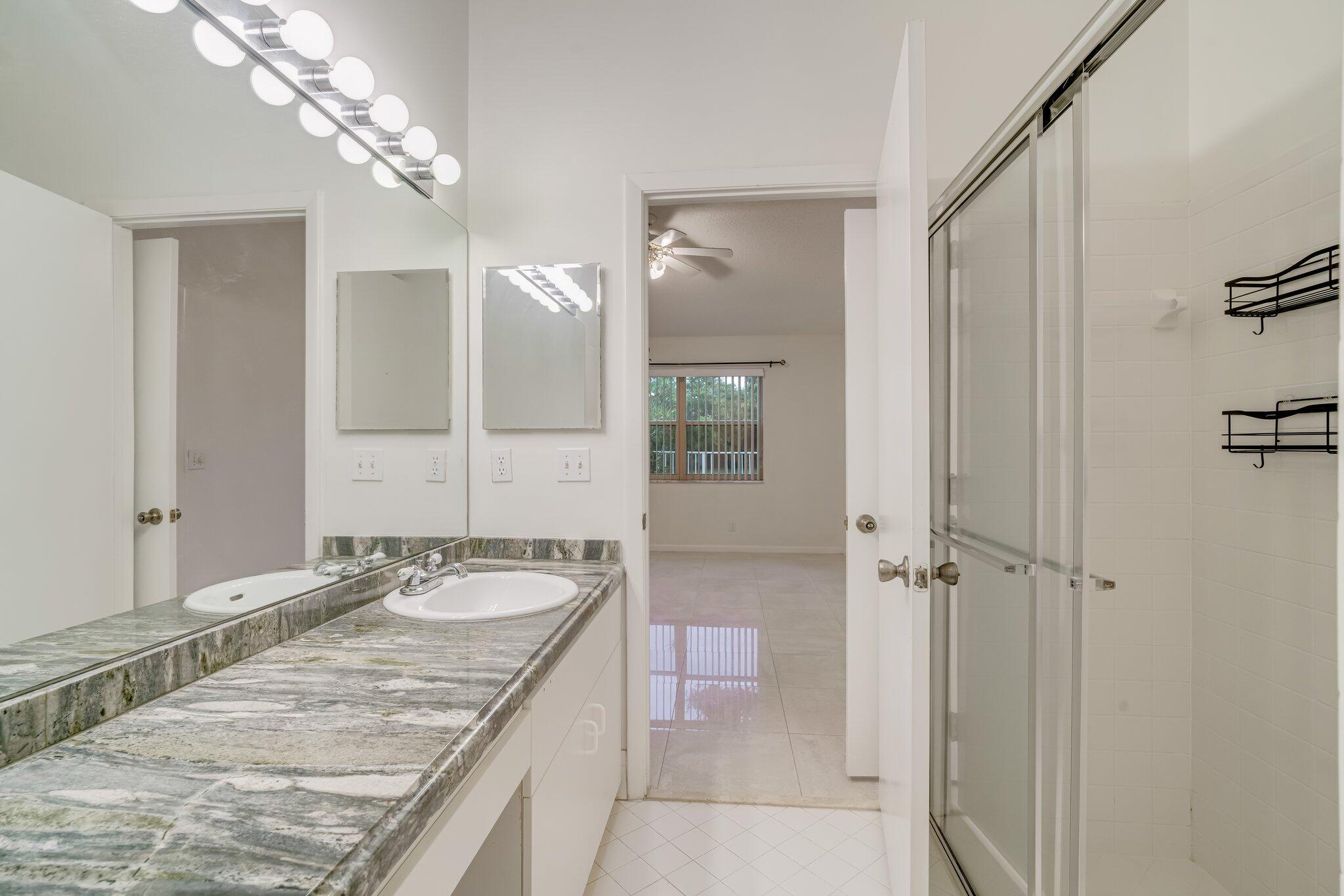 6209 Pond Tree Court Greenacres, FL 33463 - Photo 24 of 38 a bathroom with a granite countertop double vanity and a mirror