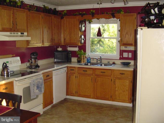 223 Killdeer Road Stephens City, VA 22655 - Photo 9 of 15 a kitchen with stainless steel appliances granite countertop a sink window and cabinets