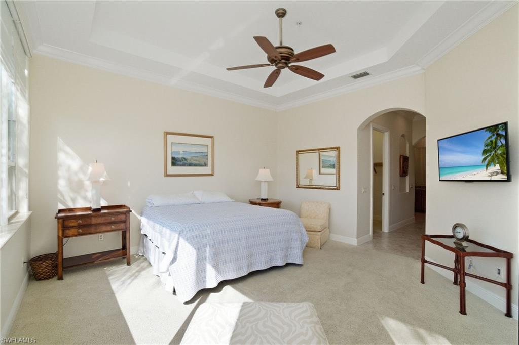 17015 Porta Vecchio Way, Unit 101 Naples, FL 34110 - Photo 13 of 39 a bedroom with a bed and a chandelier