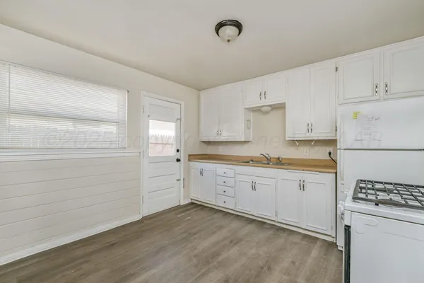 a kitchen with granite countertop cabinets appliances a sink and a window