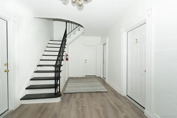a view of a hallway with wooden floor and entryway