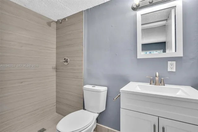 a bathroom with a toilet sink vanity and mirror