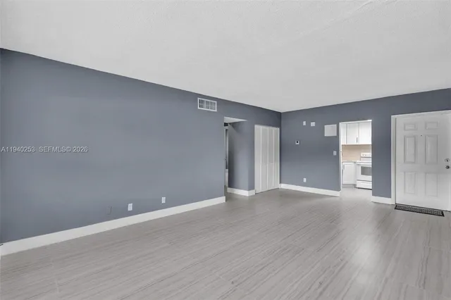 a view of an empty room with wooden floor