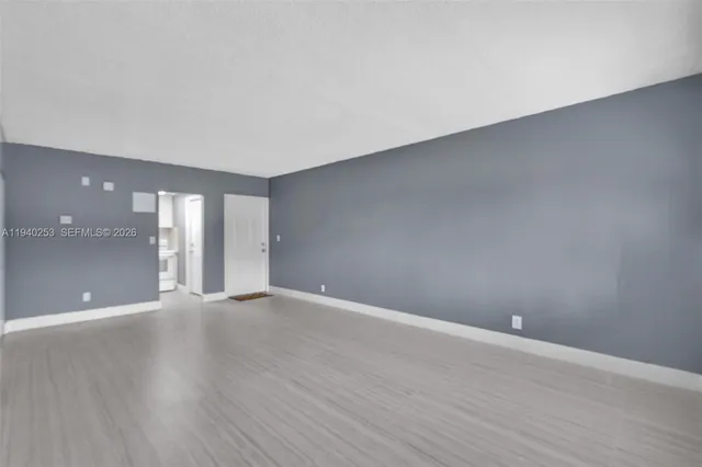 a view of an empty room with wooden floor