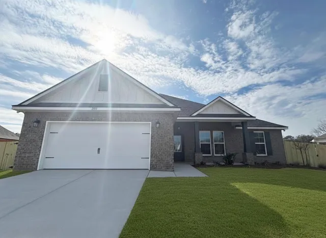 a front view of a house with a garden and yard