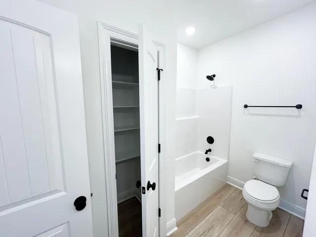 a bathroom with a toilet and a shower