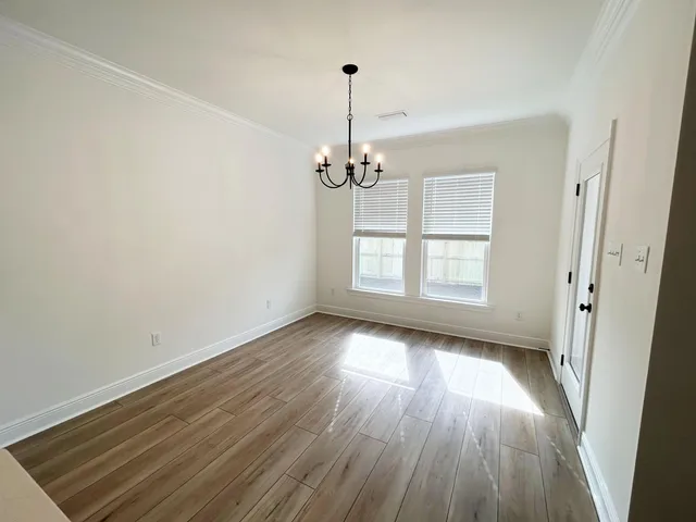 a view of a room with wooden floor closet and windows