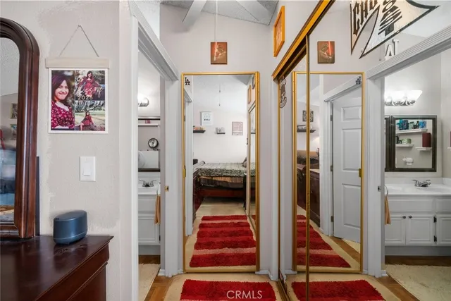 a hallway with painting on the wall and a rug