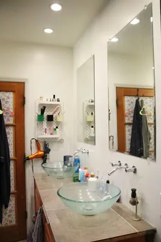 a bedroom with a bed and a flat tv screen on dresser