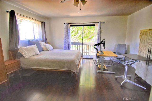 a bedroom with a bed a large window and chair