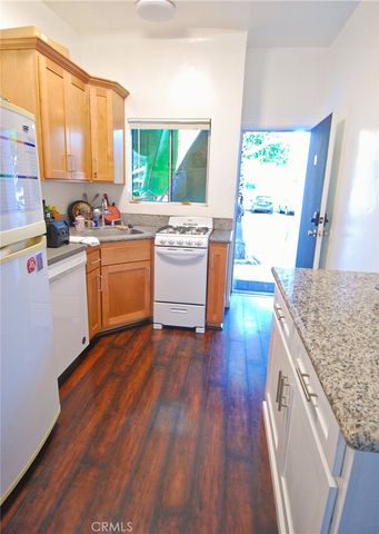 a kitchen with stainless steel appliances granite countertop a sink stove and wooden floor