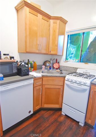 a kitchen with a sink cabinets and wooden floor