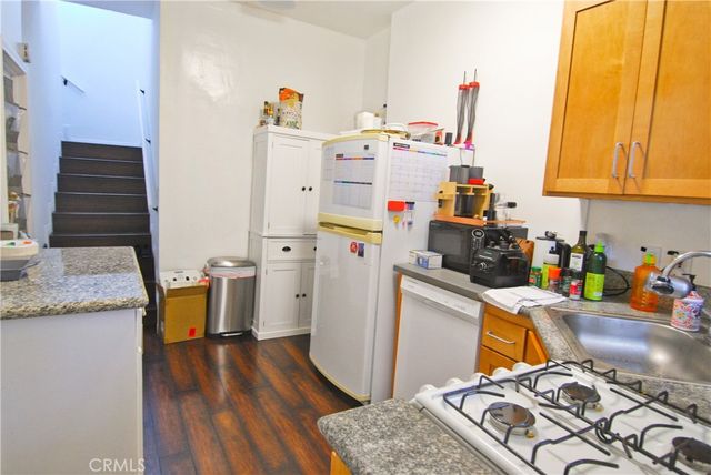 a kitchen with a refrigerator and a stove top oven