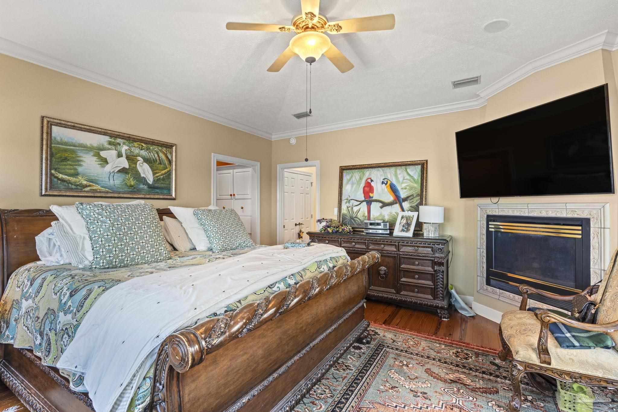 5460 North Shore Road Pensacola, FL 32507 - Photo 21 of 49 a spacious bedroom with a bed a flat screen tv and a chandelier