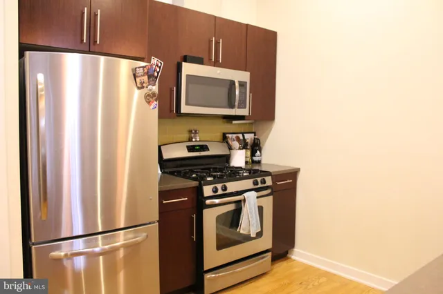a kitchen with stainless steel appliances granite countertop a refrigerator and a stove