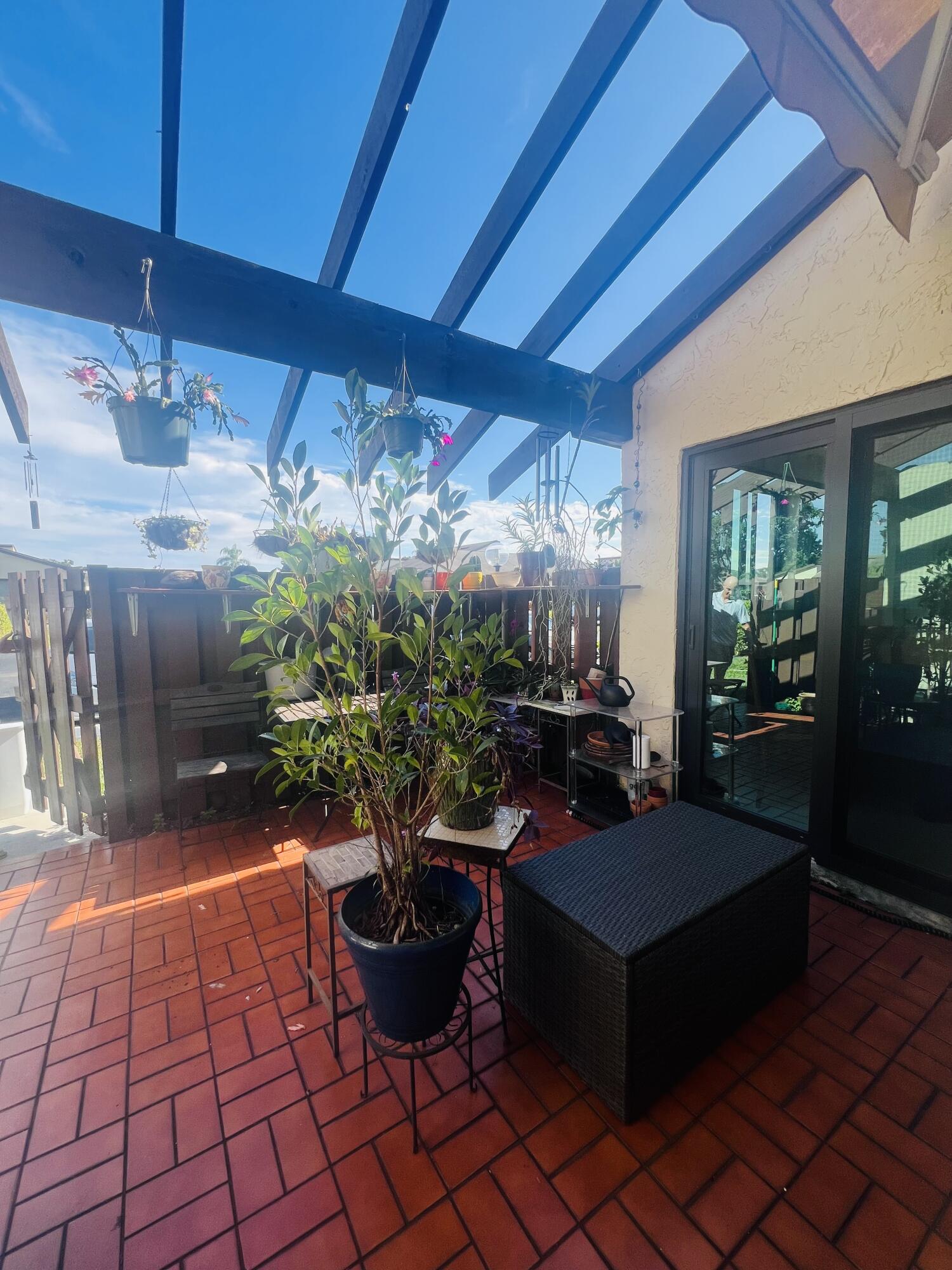 14109 Nesting Way Delray Beach, FL 33484 - Photo 3 of 12 a living room with patio furniture and potted plants