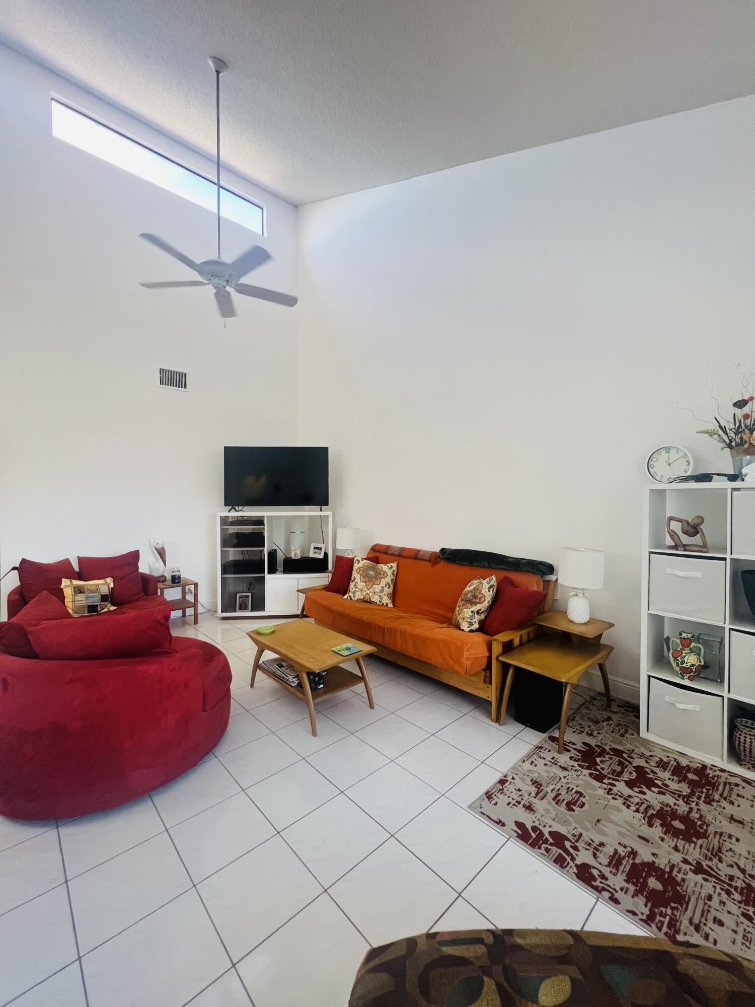 14109 Nesting Way Delray Beach, FL 33484 - Photo 6 of 12 a living room with furniture a flat screen tv and kitchen view