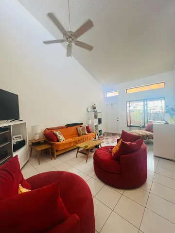 a living room with furniture a ceiling fan and a rug