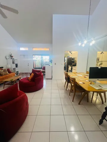 a living room with furniture a flat screen tv and kitchen view
