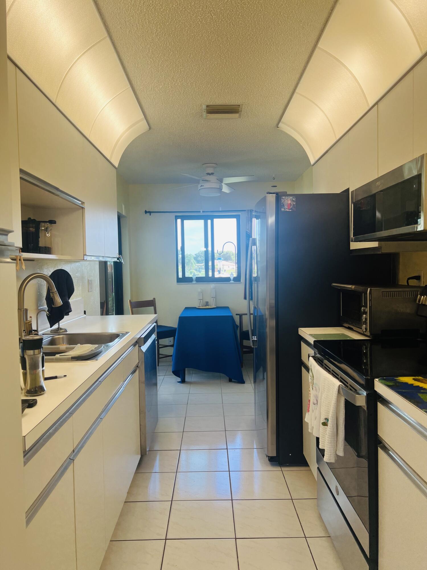 14109 Nesting Way Delray Beach, FL 33484 - Photo 10 of 12 a kitchen with stainless steel appliances granite countertop a sink and cabinets