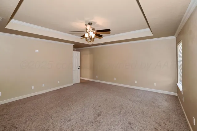 a view of an empty room with a chandelier fan