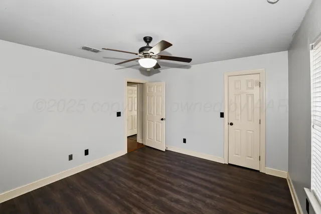 a view of a room with wooden floor and a ceiling fan