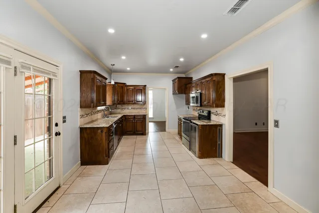 a large kitchen with a large counter top stainless steel appliances and cabinets