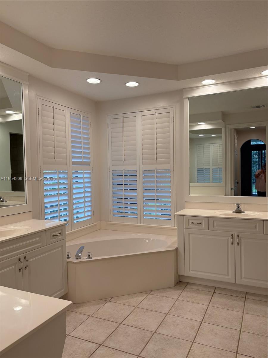 18265 Southeast Ridgeview Drive Tequesta, FL 33469 - Photo 8 of 12 a bathroom with a bathtub a sink a mirror and a shower