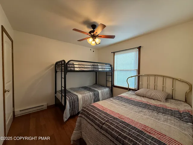 a bedroom with two beds and a ceiling fan