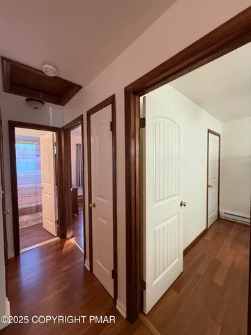 a view of a hallway with wooden floor and closet