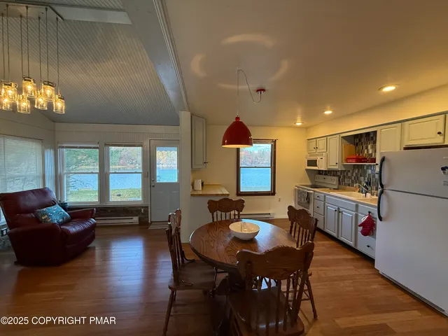 a kitchen with sink refrigerator dining table and chairs