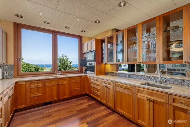 a large kitchen with stainless steel appliances granite countertop a large window and a sink