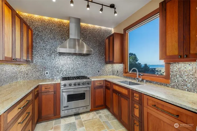 a kitchen with stainless steel appliances granite countertop a sink stove and cabinets