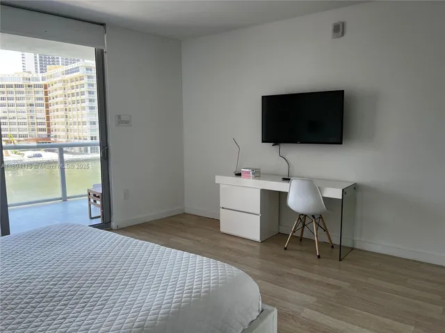 a bedroom with a bed and a flat screen tv