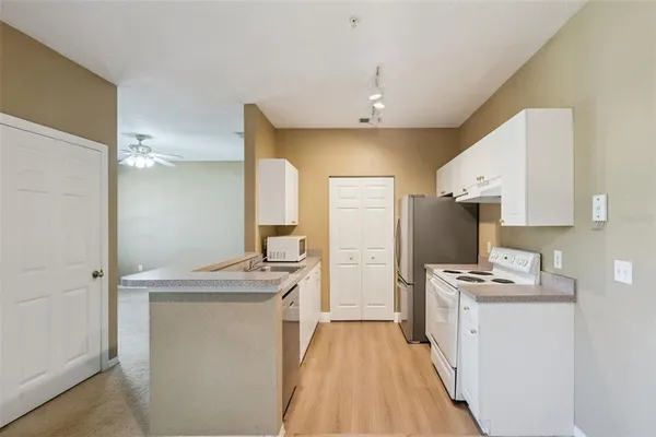 a kitchen with kitchen island a sink stove and refrigerator