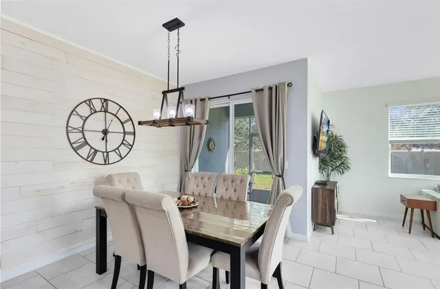 a kitchen with stainless steel appliances kitchen island granite countertop a stove top oven a sink a dining table and chairs