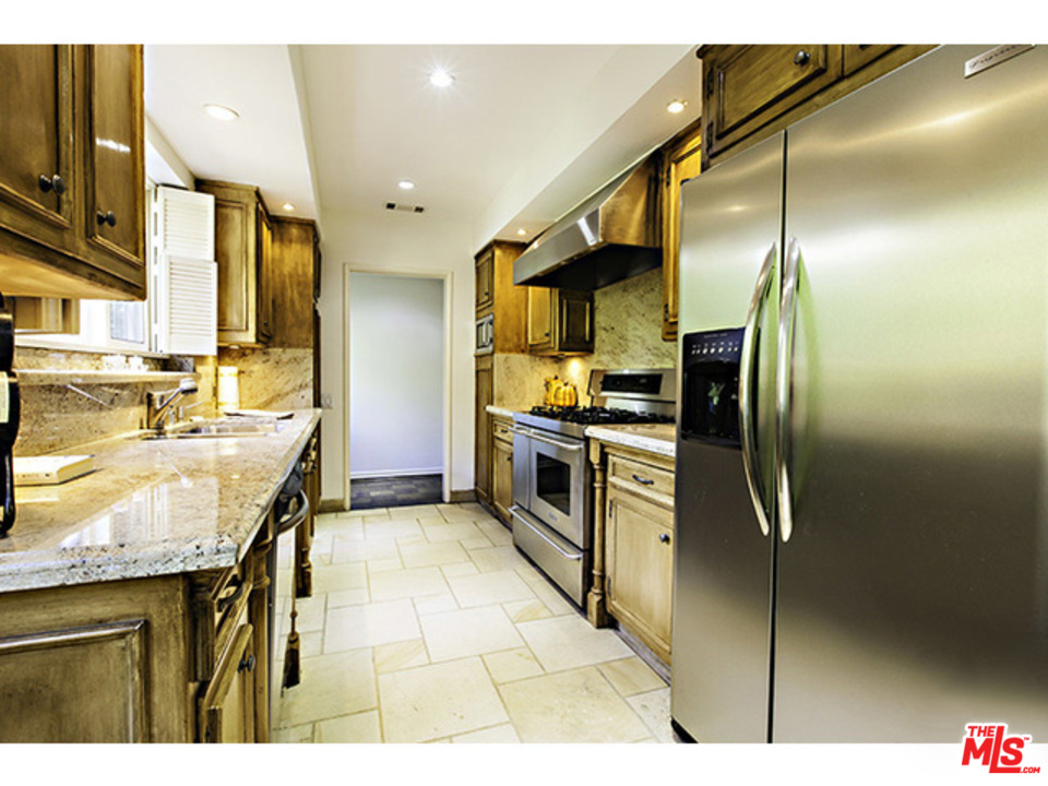 2559 Hutton Drive Beverly Hills, CA 90210 - Photo 4 of 13 a kitchen with stainless steel appliances granite countertop a sink and a refrigerator
