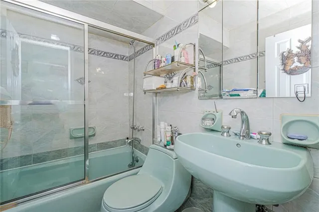 a bathroom with a sink and mirror with toilet