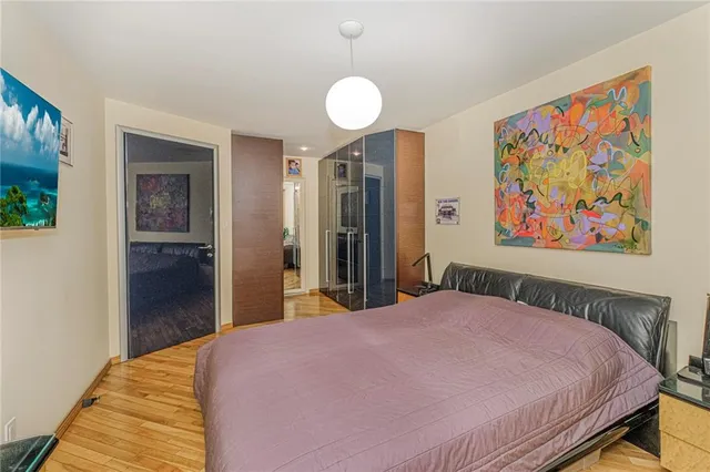 a bedroom with a bed and a painting on the wall