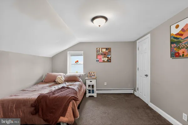 a bedroom with a bed and painting on the wall