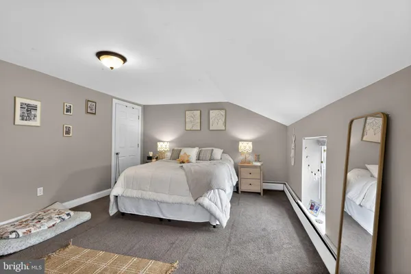 a spacious bedroom with a bed and a lamp