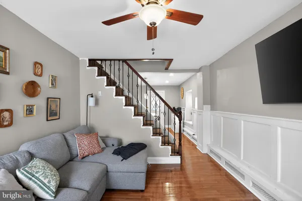 a living room with couches and a flat screen tv with wooden floor
