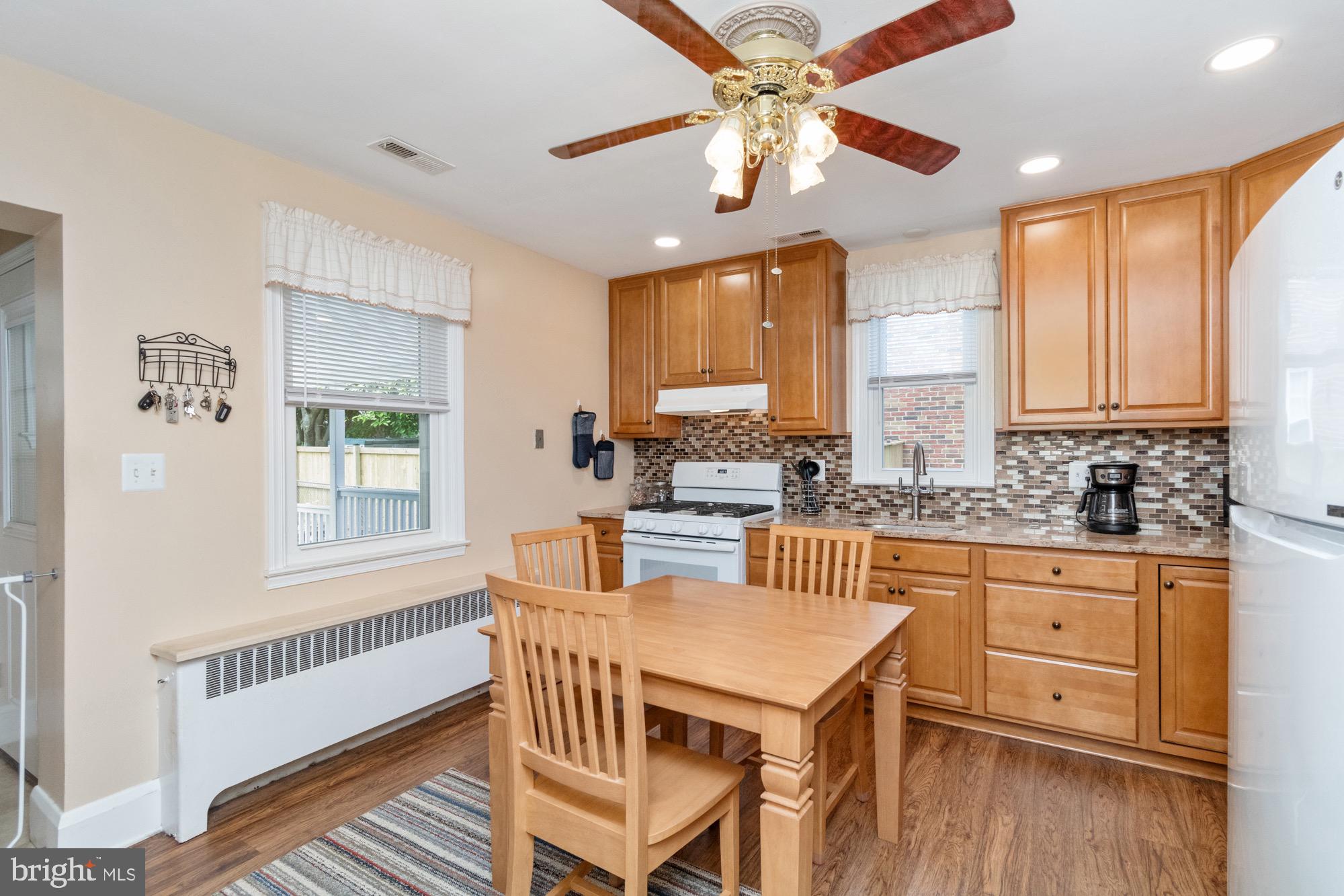 4305 Fullerton Avenue Baltimore, MD 21206 - Photo 11 of 36 a view of a kitchen with granite countertop a table chairs a sink a window and cabinets