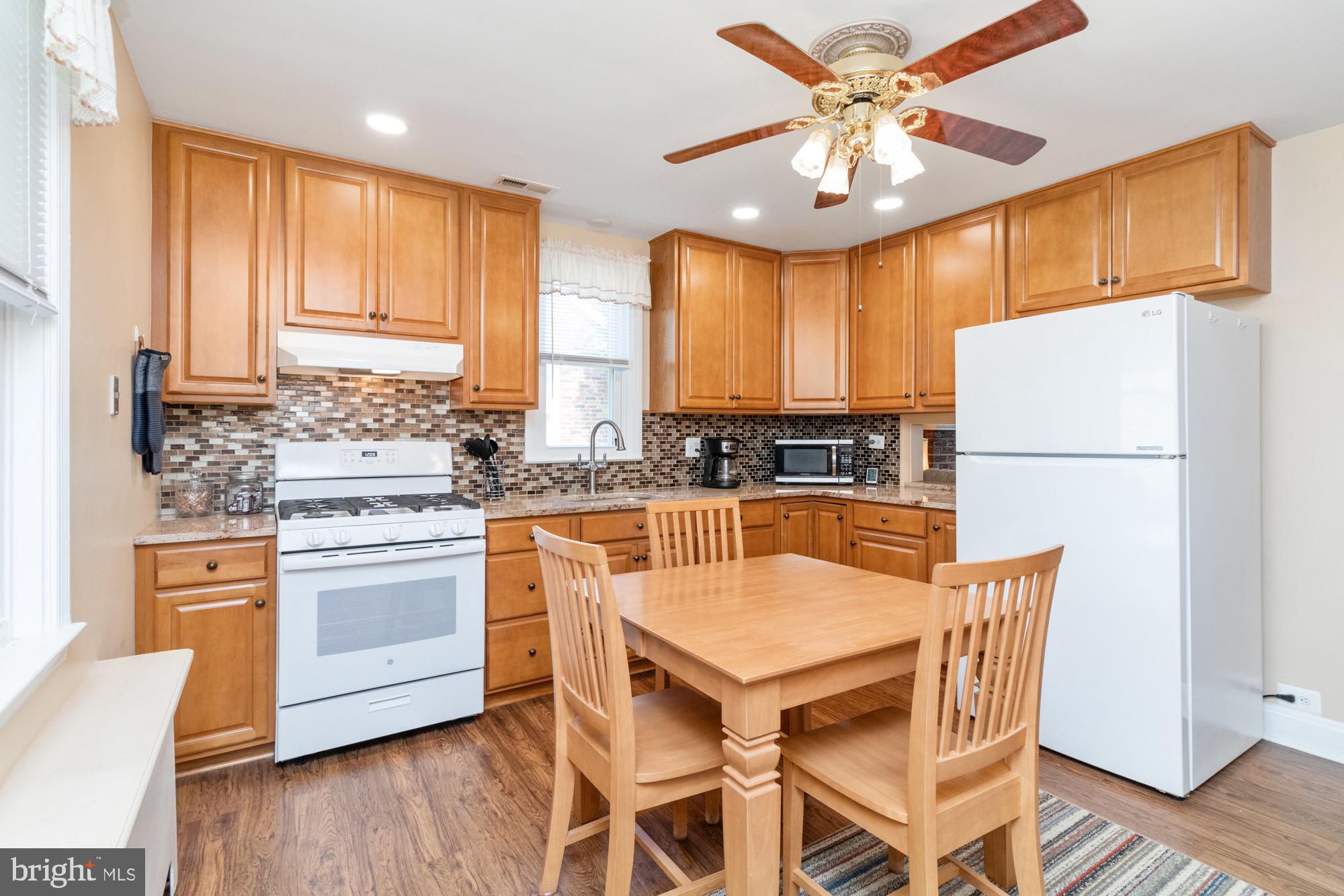 4305 Fullerton Avenue Baltimore, MD 21206 - Photo 9 of 36 a kitchen with stainless steel appliances granite countertop a stove a refrigerator a microwave a sink and white cabinets